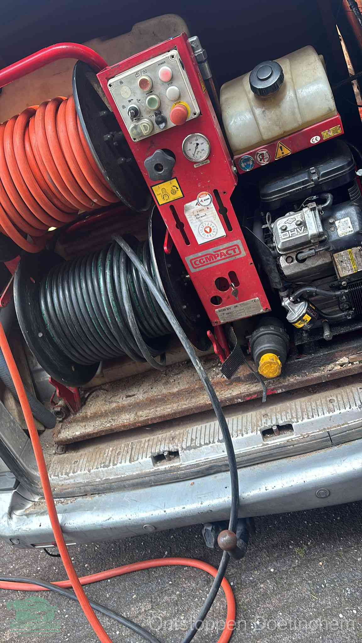 Een rood hogedruk-rioolreinigingstoestel in de laadbak van de bedrijfsbus, apparatuur voor een hardnekkige afvoerverstopping in Doetinchem