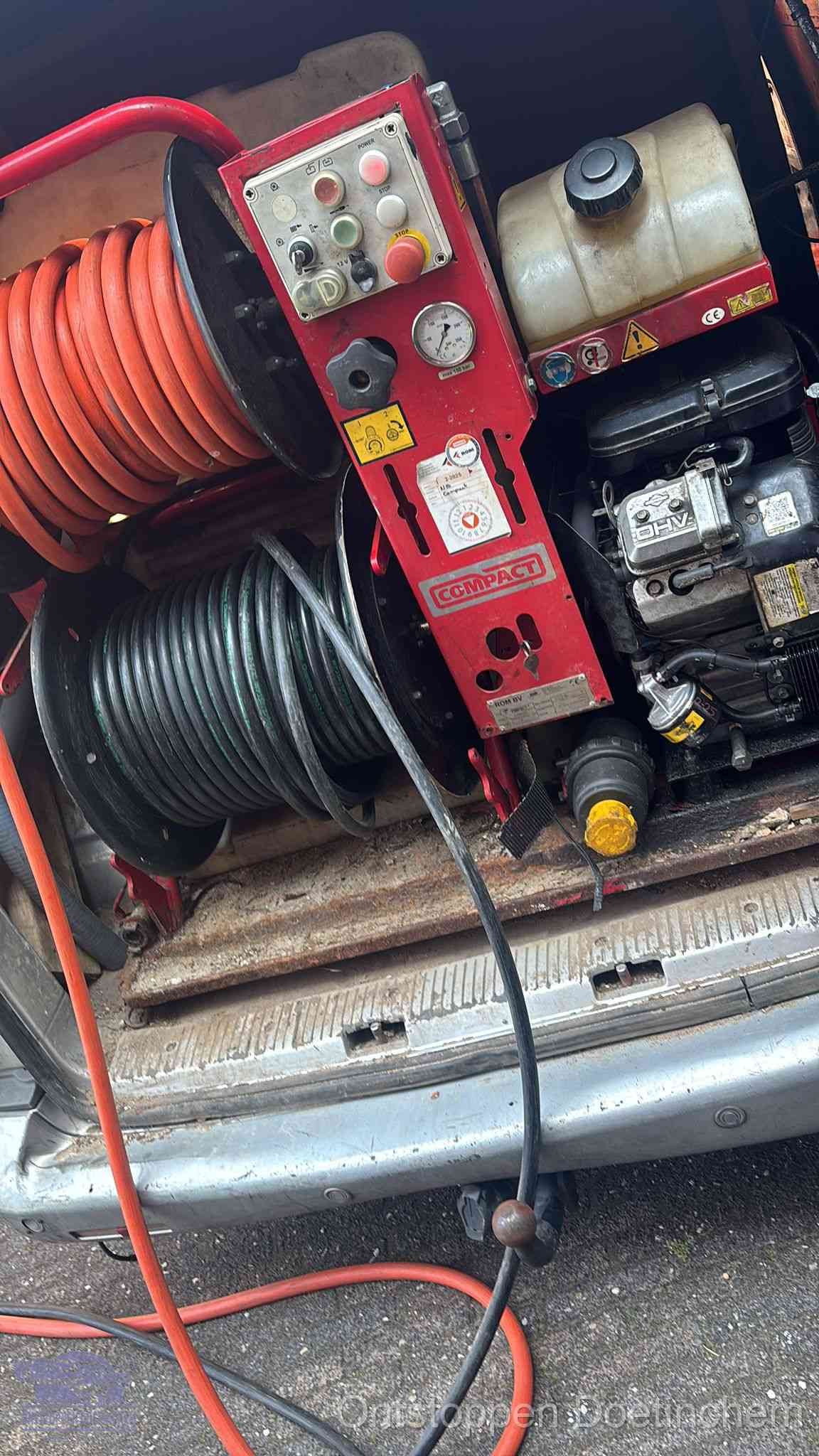 Een rood hogedruk-rioolreinigingstoestel met slangen in de laadbak van de bedrijfsbus, apparatuur voor een hardnekkige wc-verstopping in Doetinchem