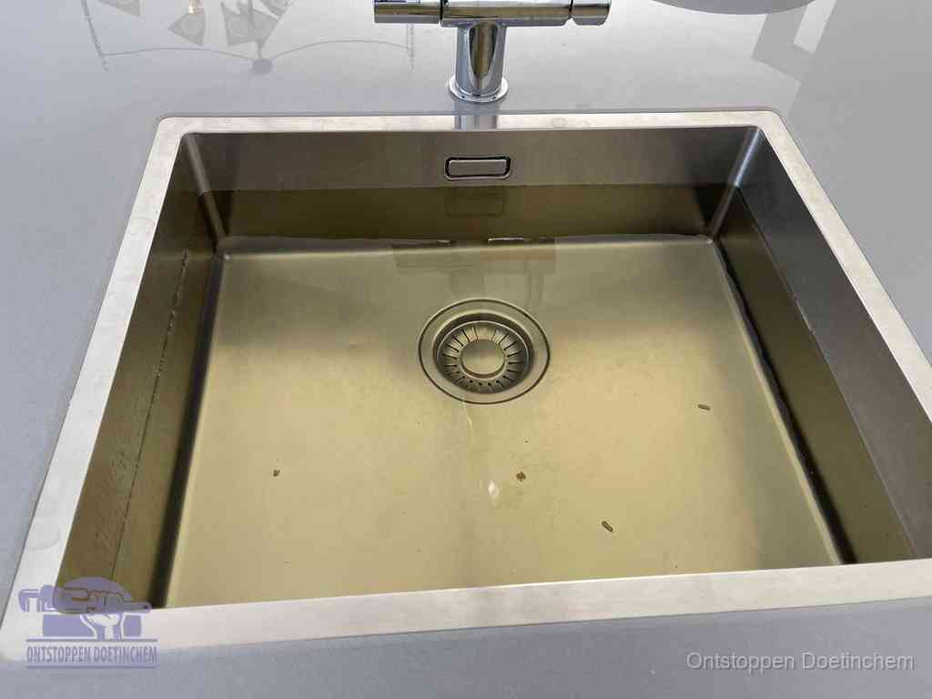 Stilstaand water in een rvs spoelbak dat niet wegloopt, een duidelijk signaal van een gootsteenverstopping in Doetinchem