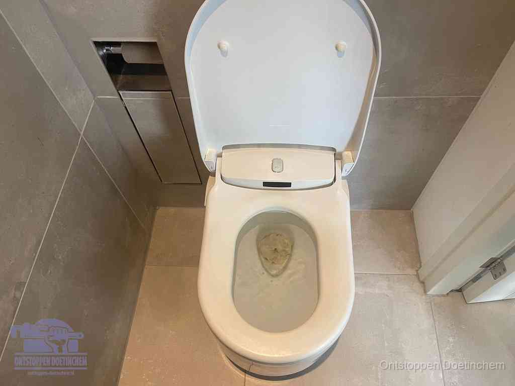 Een wit hangtoilet waarin een prop wc-papier op het water blijft drijven, een duidelijk signaal van een verstopte wc in Doetinchem