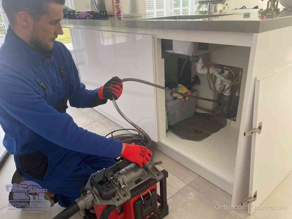 Een monteur reinigt de keukenafvoer grondig met een veermachine om terugkerende gootsteenverstoppingen te voorkomen in Doetinchem