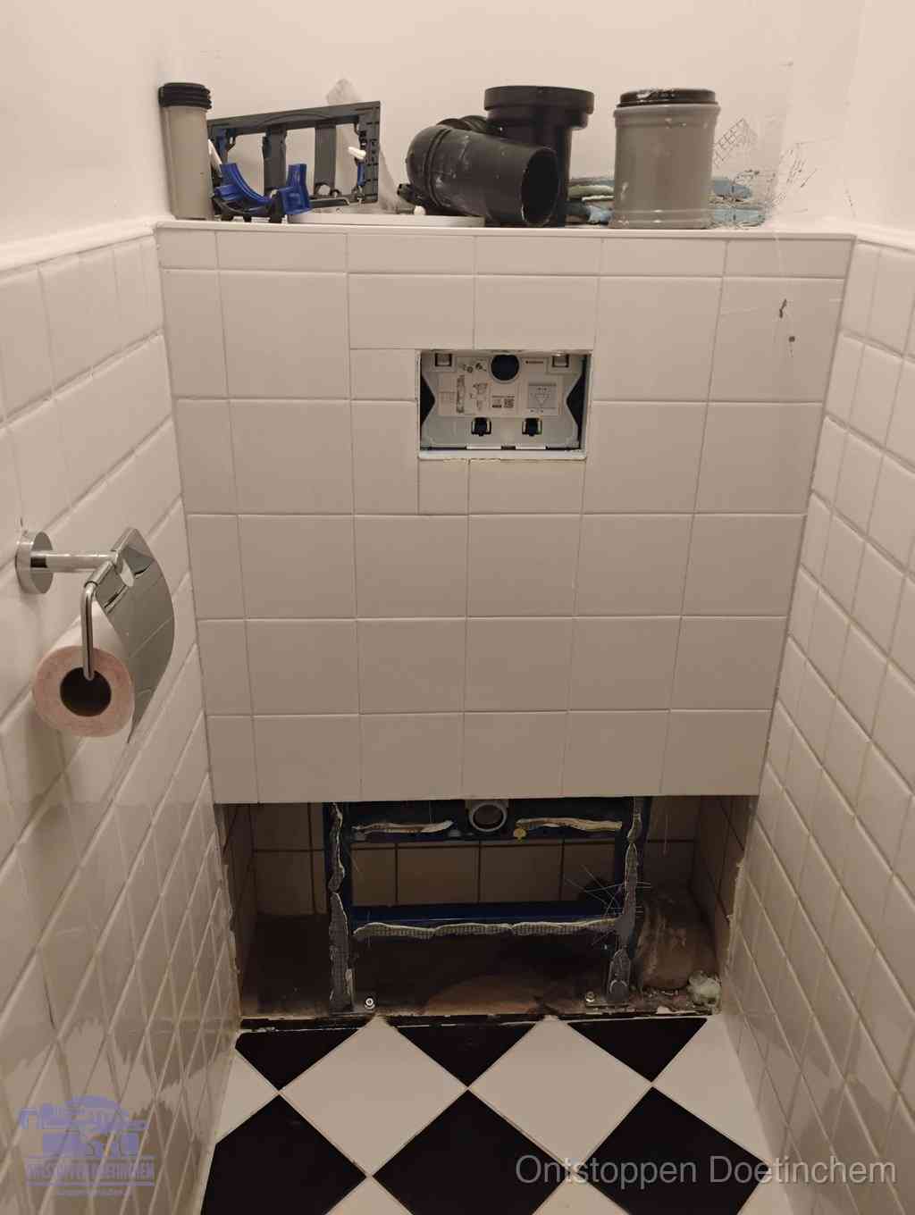 Een toiletruimte waar het hangtoilet en de inbouwreservoir-onderdelen zijn vrijgelegd voor onderhoud, periodiek nazicht voorkomt een wc-verstopping in Doetinchem